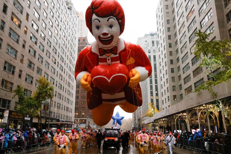 A Ronald McDonald float travels down a central Manhattan street.
