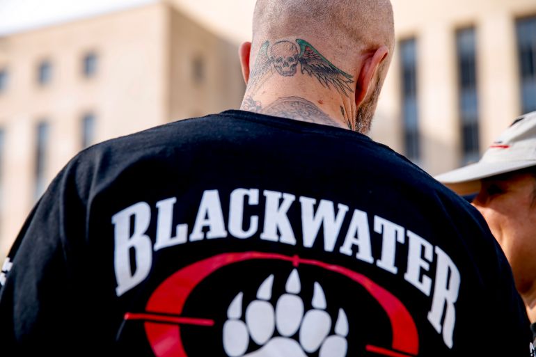 A former member of Blackwater joines family members, friends, and supporters of four former Blackwater security guards outside the federal court in Washington, Monday, April 13, 2015, following sentencing for four former Blackwater security guards in connection with a 2007 shooting of civilians in Iraq. U.S. District Judge Royce Lamberth sentenced Nicholas Slatten to life in prison while Paul Slough of Keller, Texas, Evan Liberty of Rochester, N.H., and Dustin Heard of Knoxville, Tenn., were convicted of manslaughter and received sentences of 30 years plus one day. (AP Photo/Andrew Harnik)